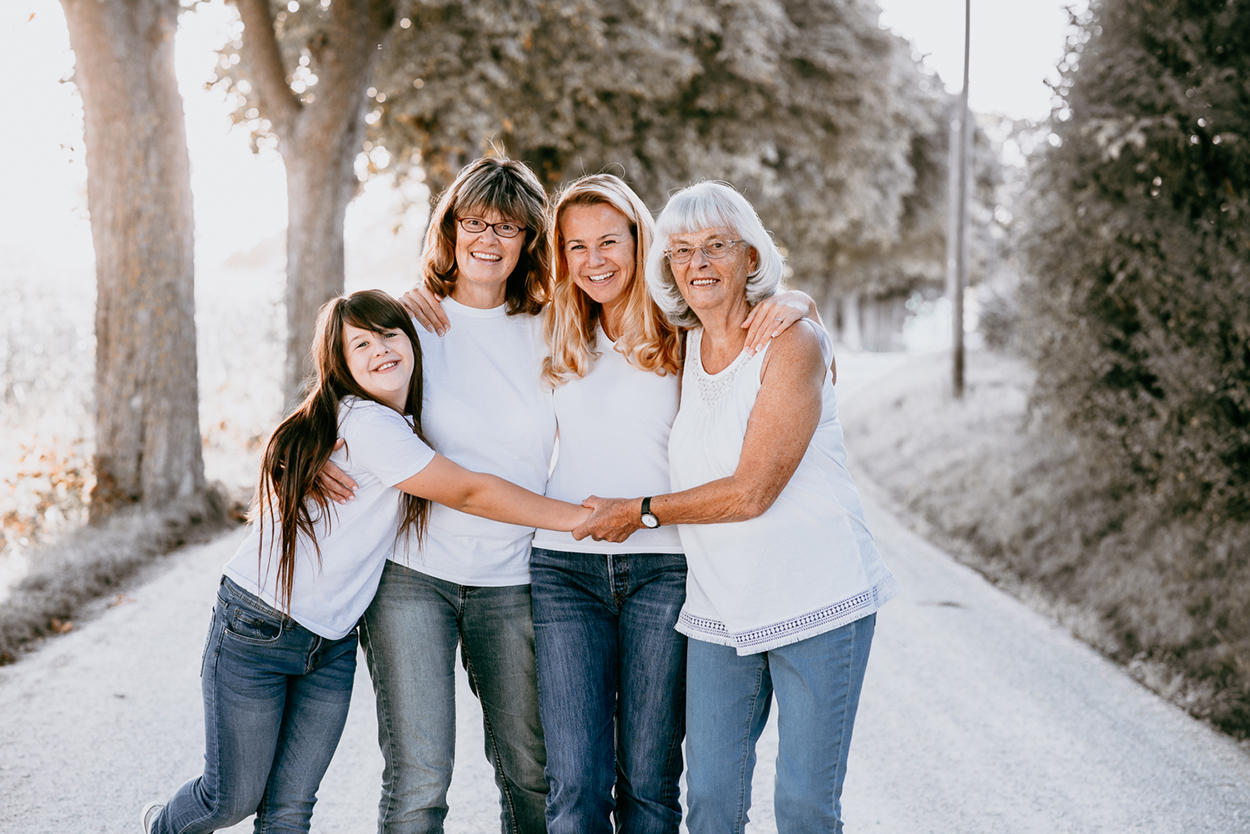 Familie mit mehreren Generationen steht gemeinsam lachend im Freien – natürliche Familienfotografie von Stefanie Cypris Fotografin Nürnberg Schwabach Roth Fürth