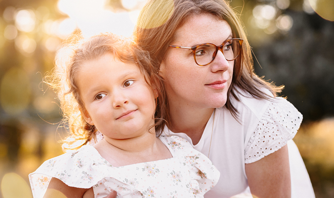 Mutter mit Kind im Arm im warmen Sonnenlicht draußen – natürliche Familienfotografie von Stefanie Cypris Fotografin Nürnberg Schwabach Roth Fürth